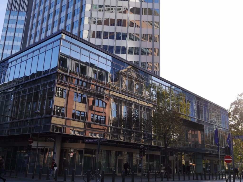 prédios antigos refletem em um novo edifício